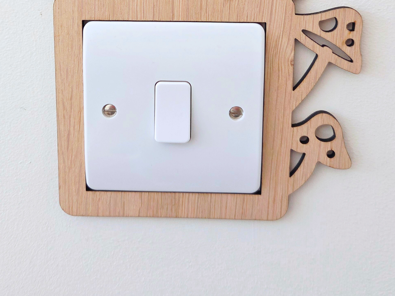 A wooden mushroom-shaped light switch on a wall.