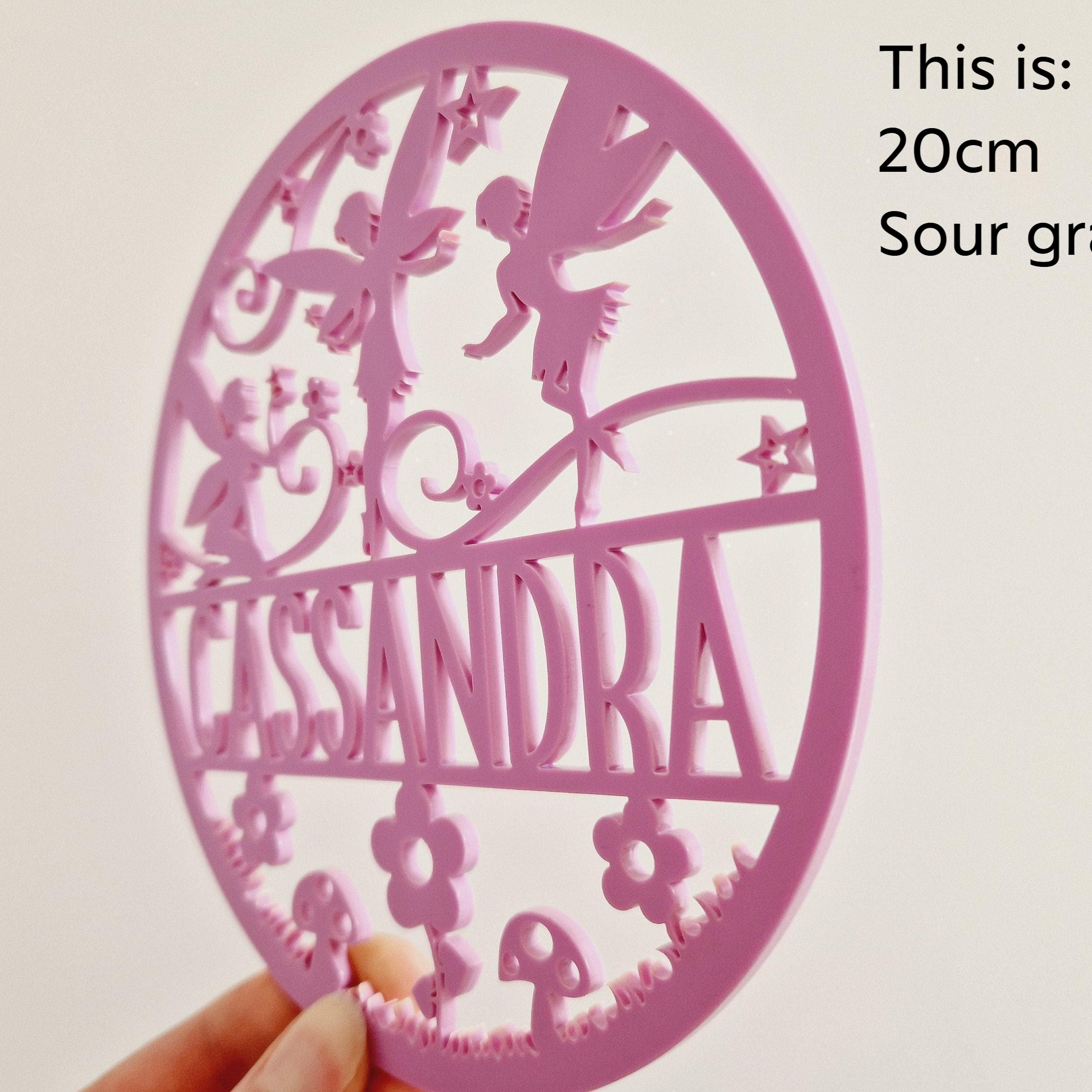 a pink, circular object with the name 'CASSANDRA' written on it.