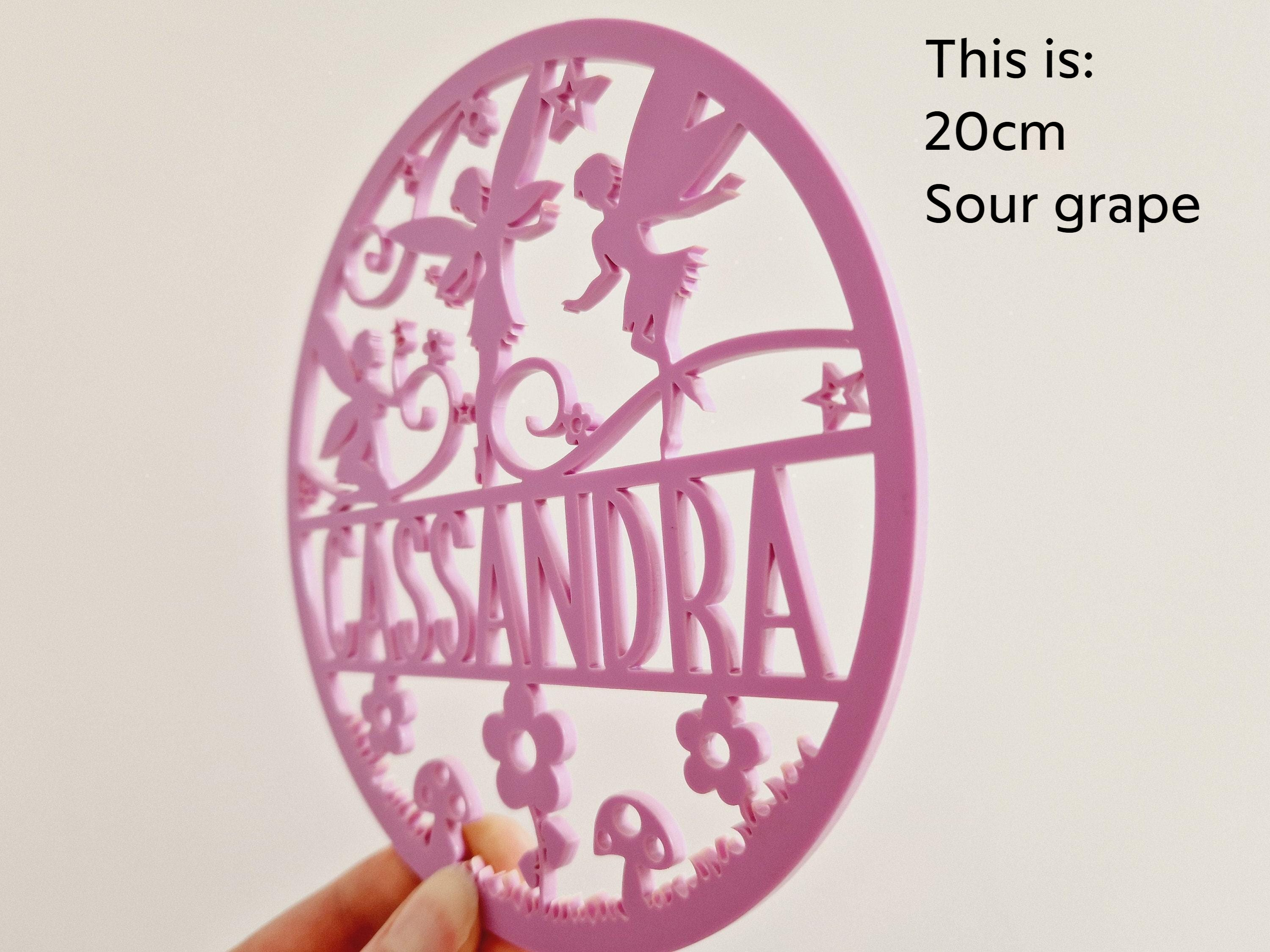 a pink, circular object with the name 'CASSANDRA' written on it.