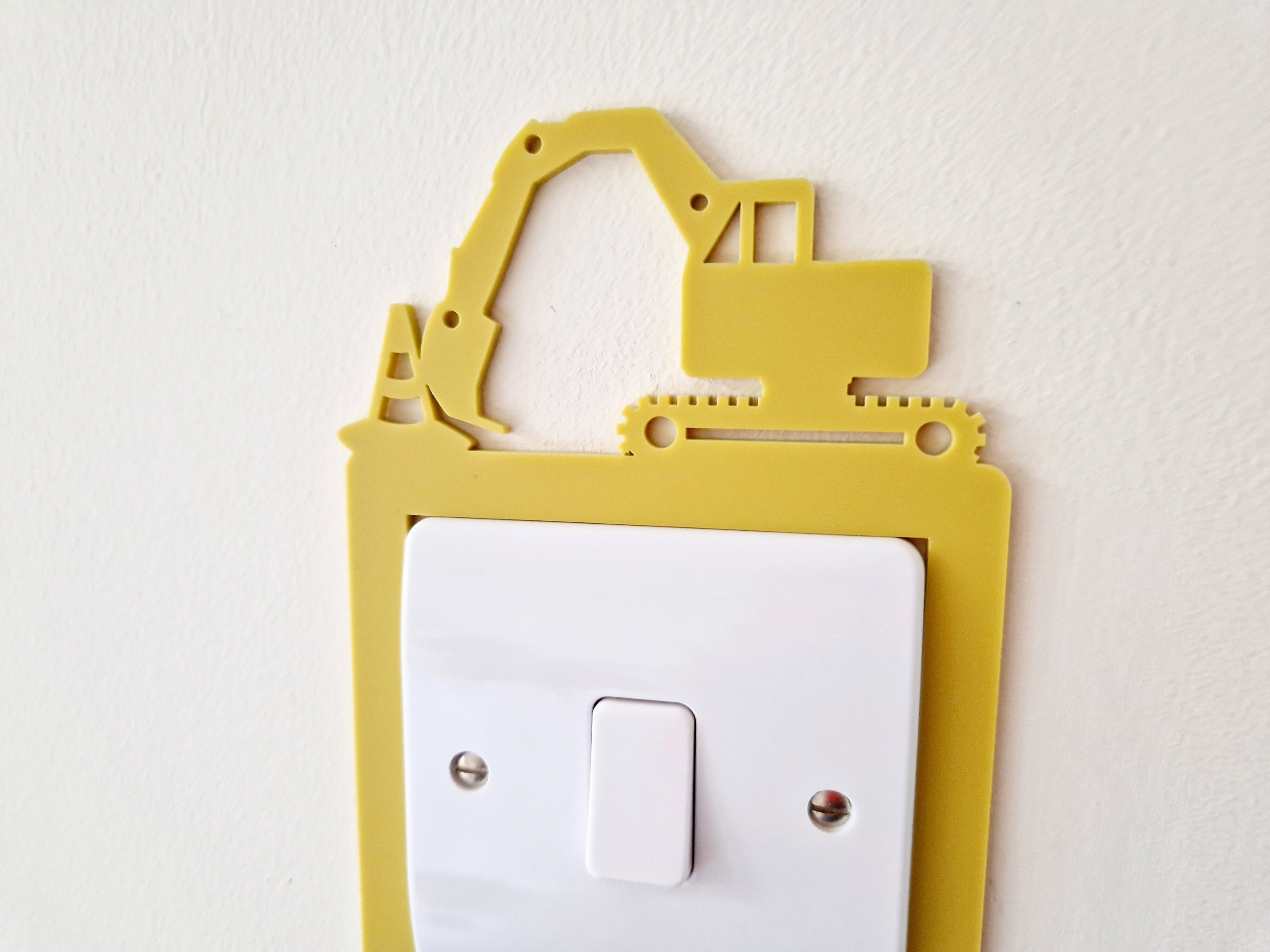 A yellow plastic construction vehicle-shaped light switch on a white wall.