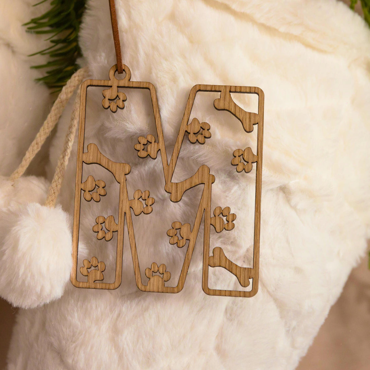 Wooden stocking tag with paws and bone design.