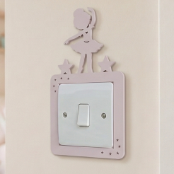Decorative pink light switch cover with a dancing ballerina design in a child's room.