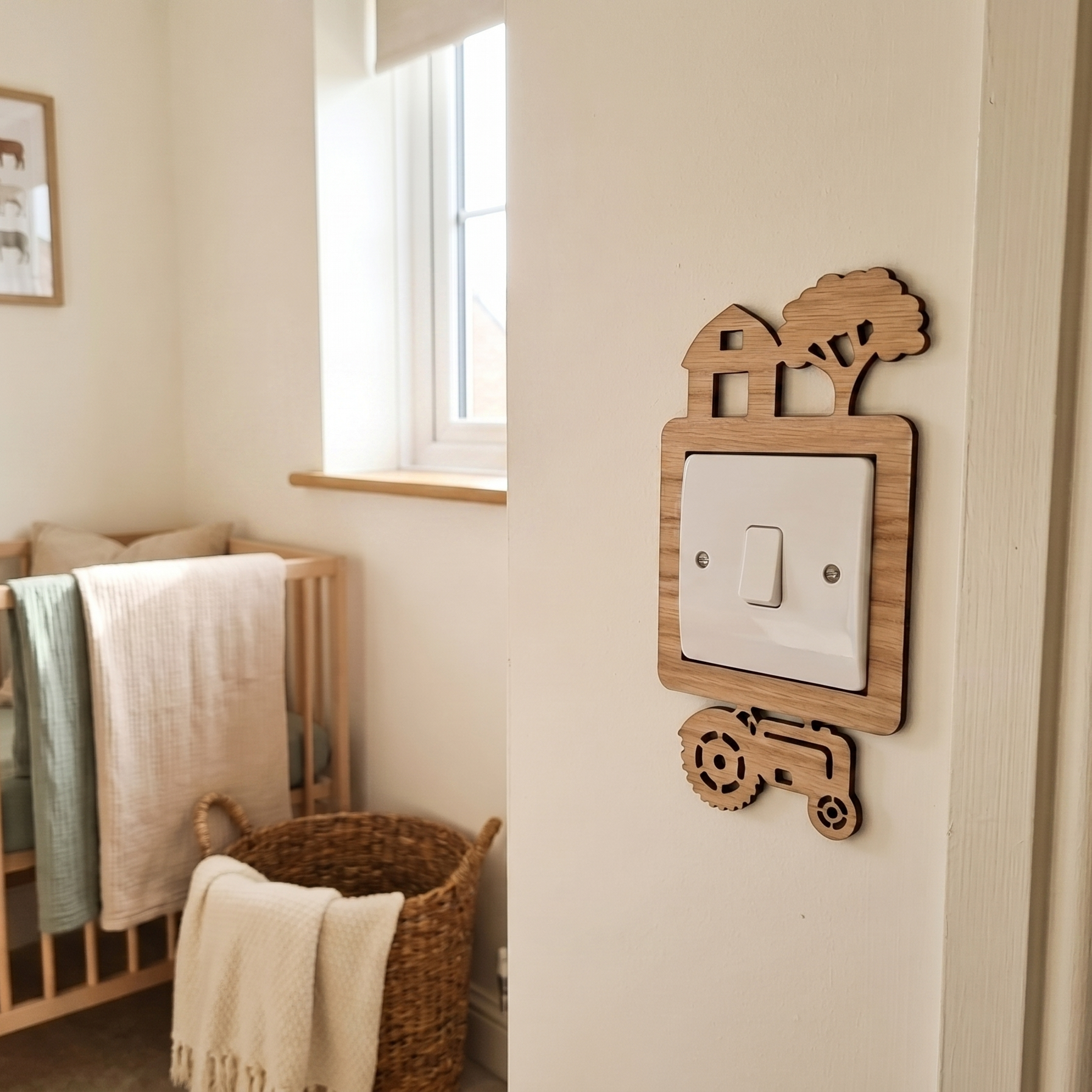 Nursery room with wooden crib, basket, and wooden decorative light switch cover with a barn, tree and tractor design.