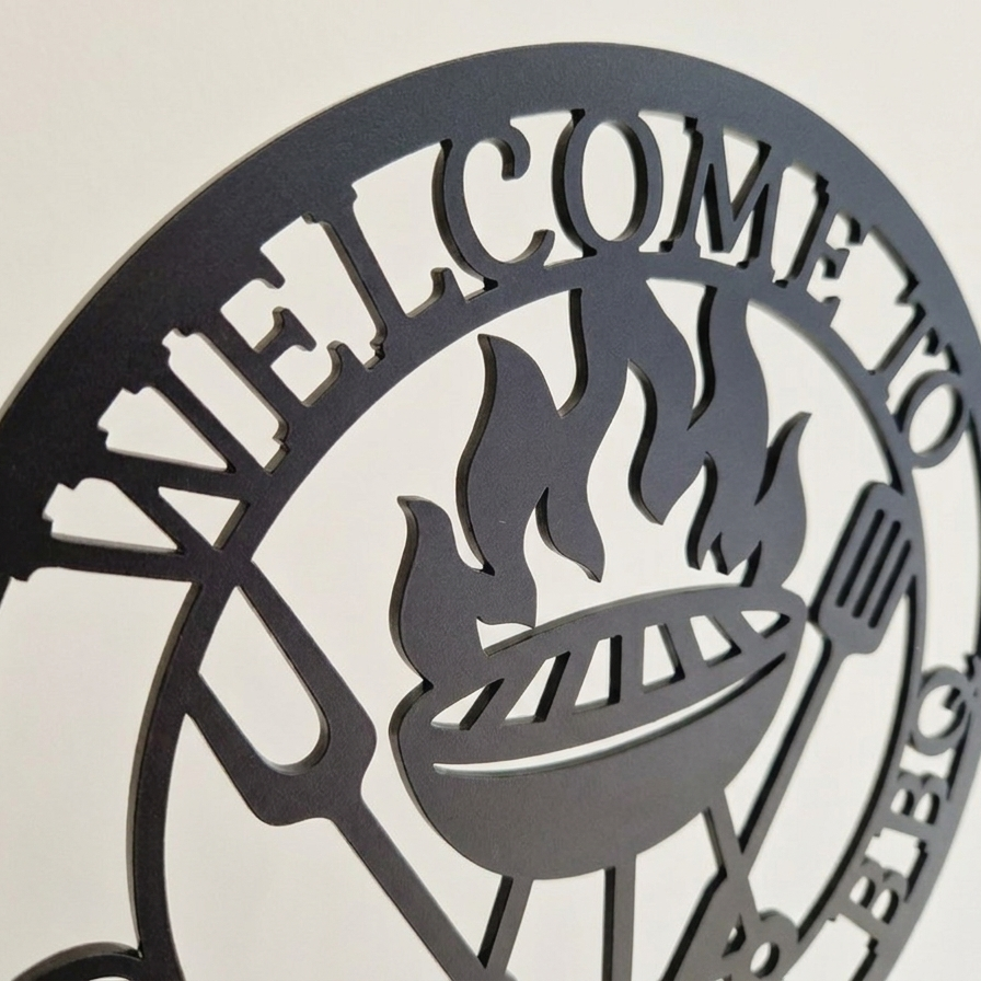 Close up of decorative acrylic sign with 'Welcome to Grandad's BBQ' text and grill icon on a beige background