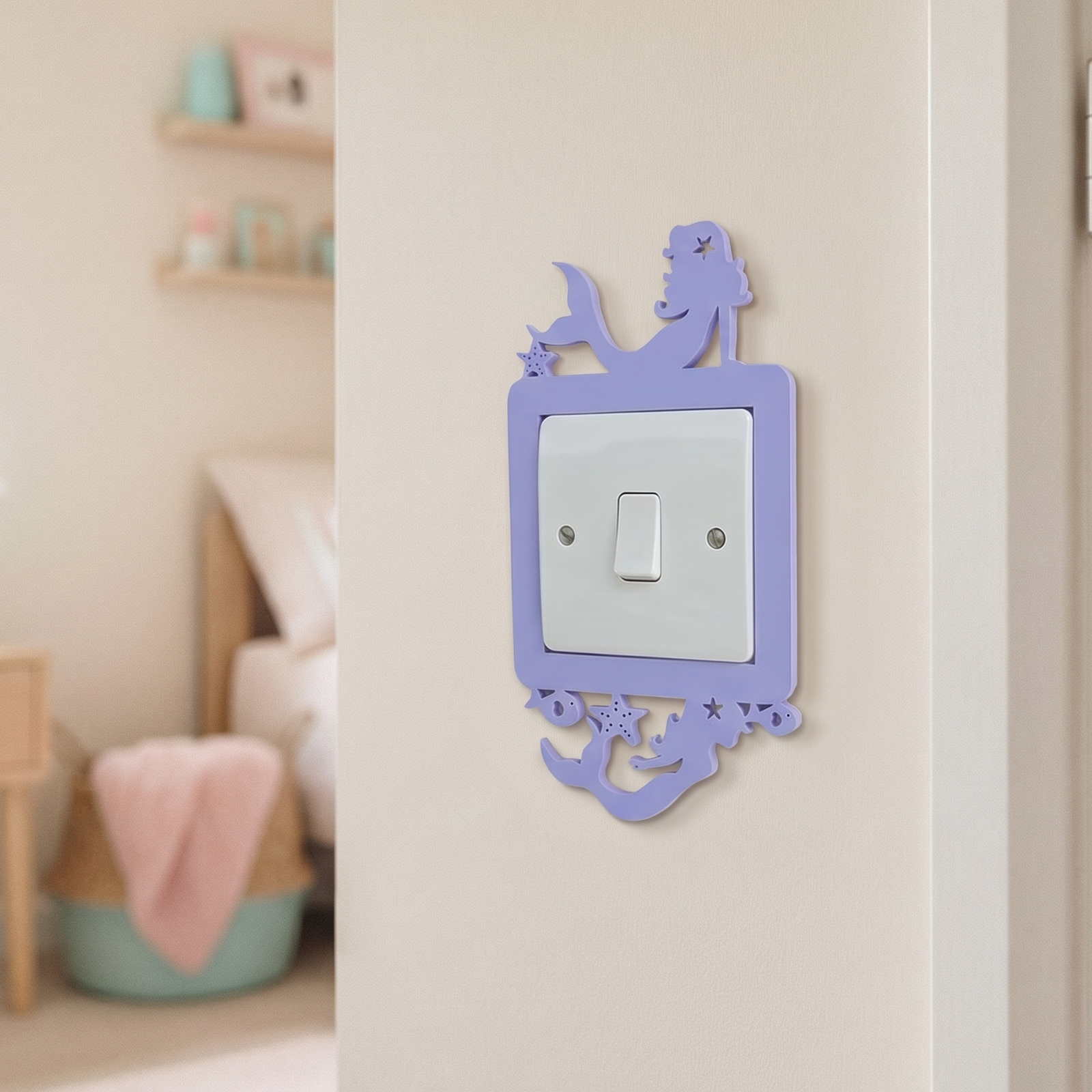 Decorative switch cover in lilac with a mermaid design on a wall in a child's room.