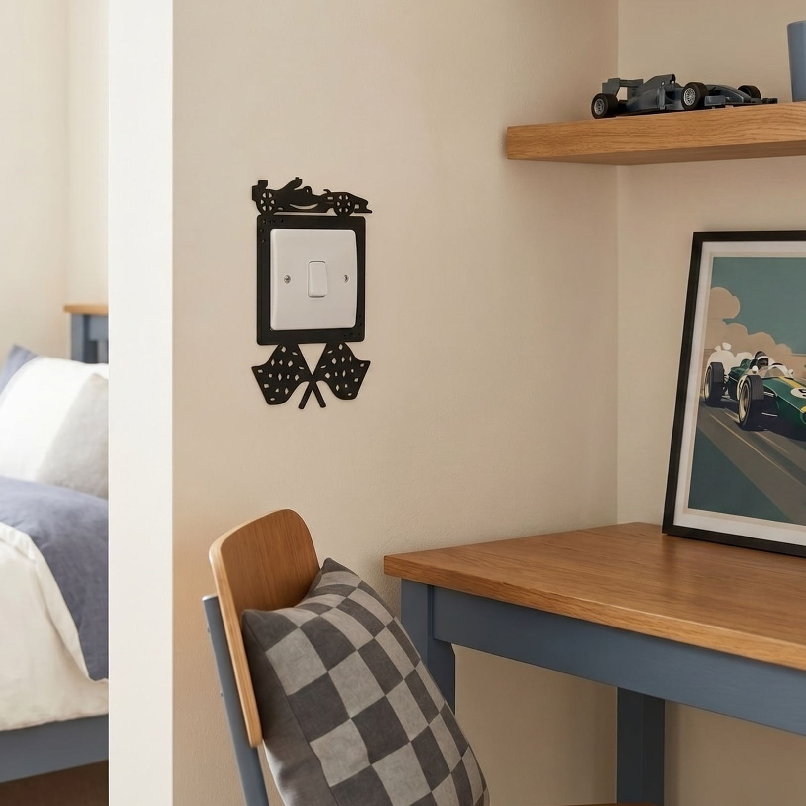 Small bedroom with a bed, desk, and a black switch surround with a racing car and finishing flags.