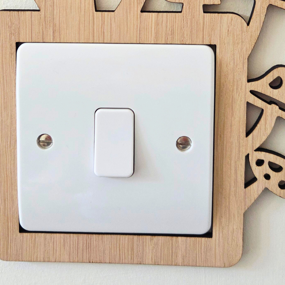A wooden light switch with a white switch plate mounted on a wall.