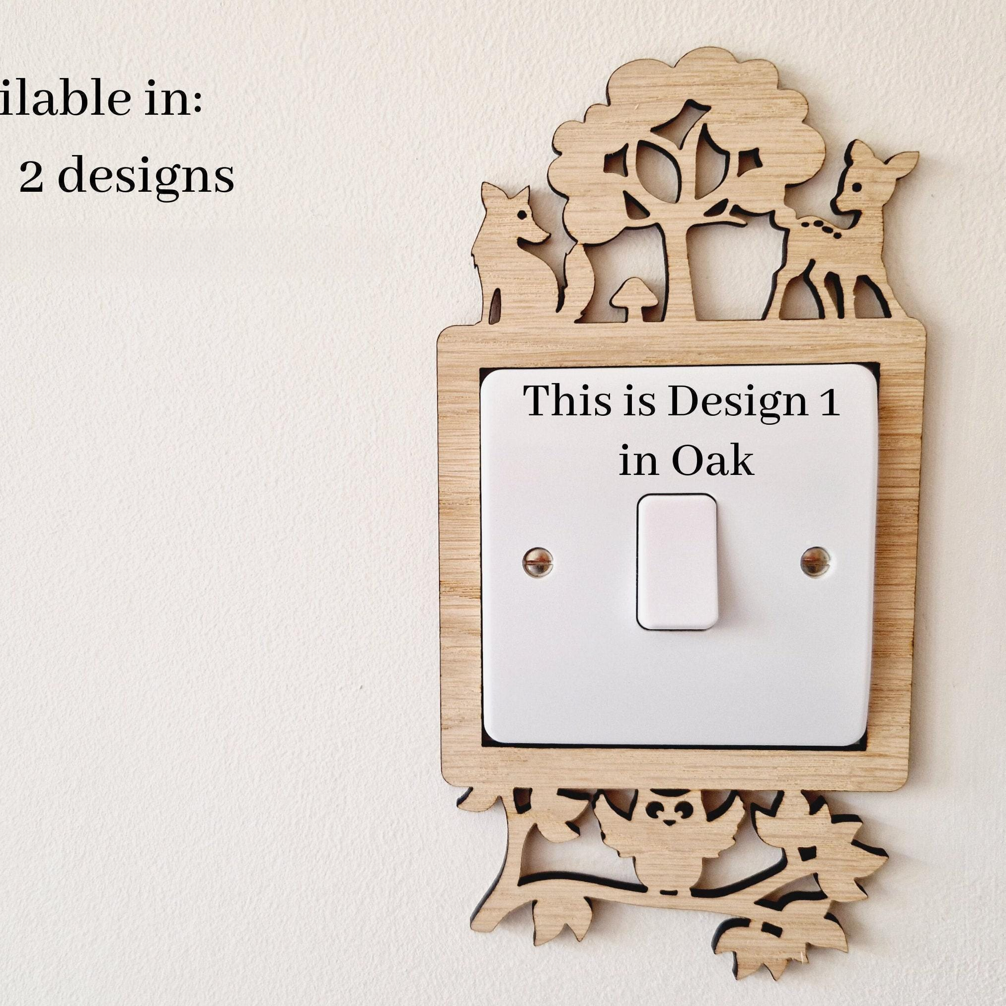 a wooden light switch surround with a cut out woodland scene design with a deer, fox and owl.