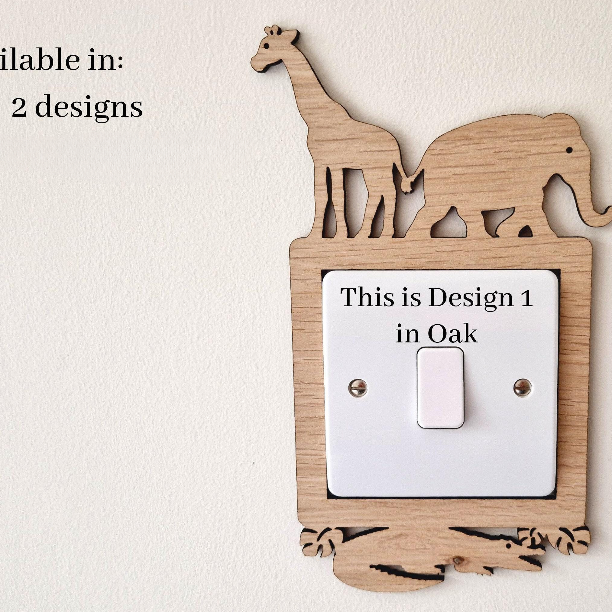 a wooden light switch with a giraffe and an elephant cut out of it, mounted on a wall.
