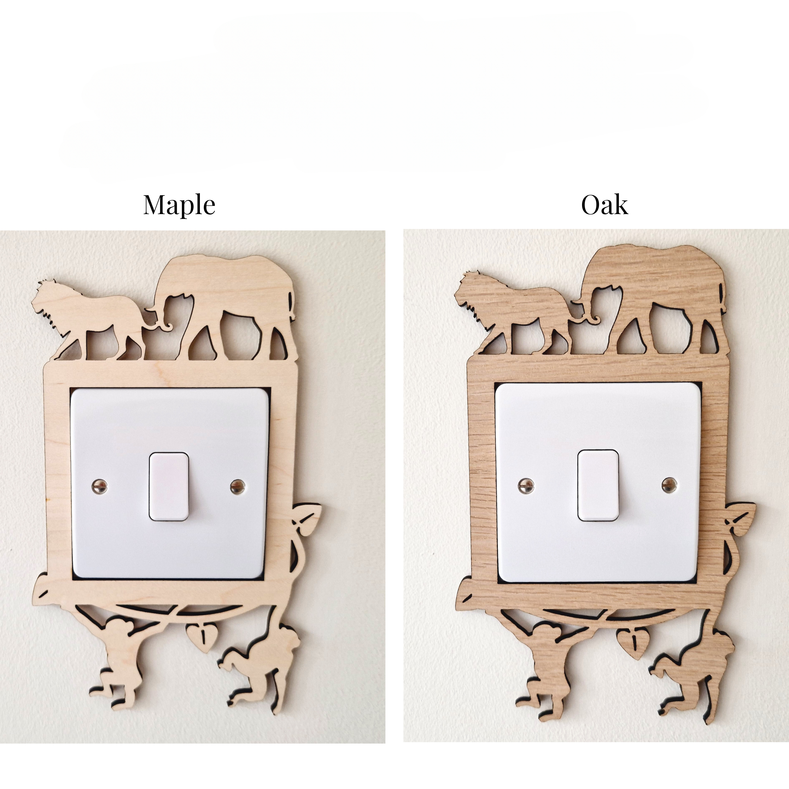 two different wooden light switch covers, each featuring a unique animal silhouette design. The switch cover on the left is labeled "Maple" and the one on the right is labeled "Oak".