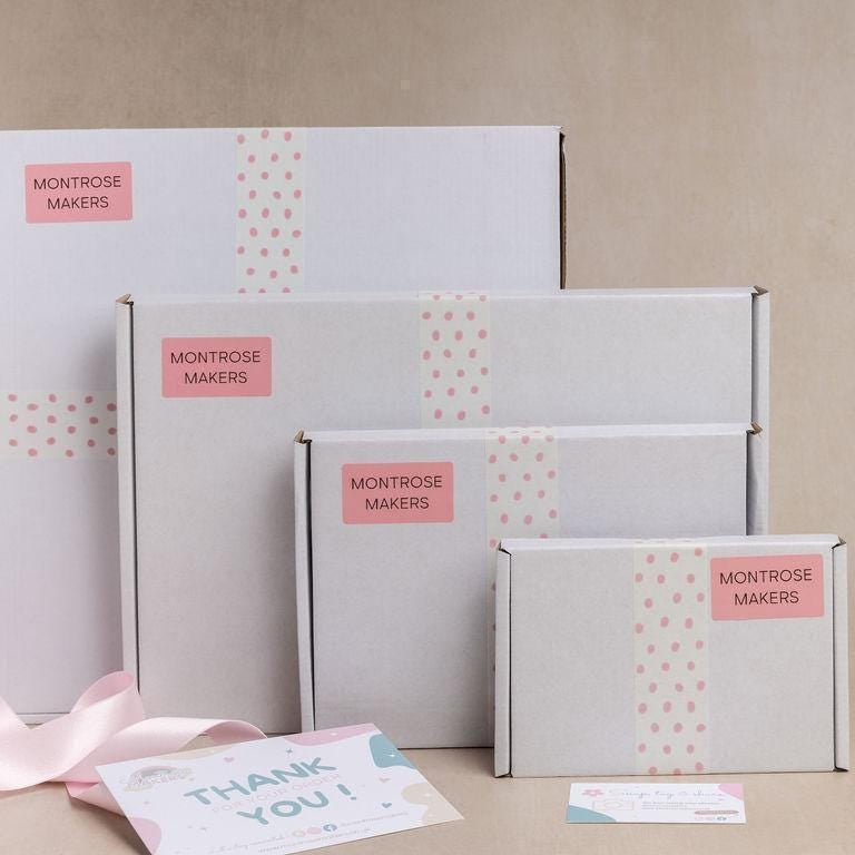 a bunch of boxes with pink ribbons on them