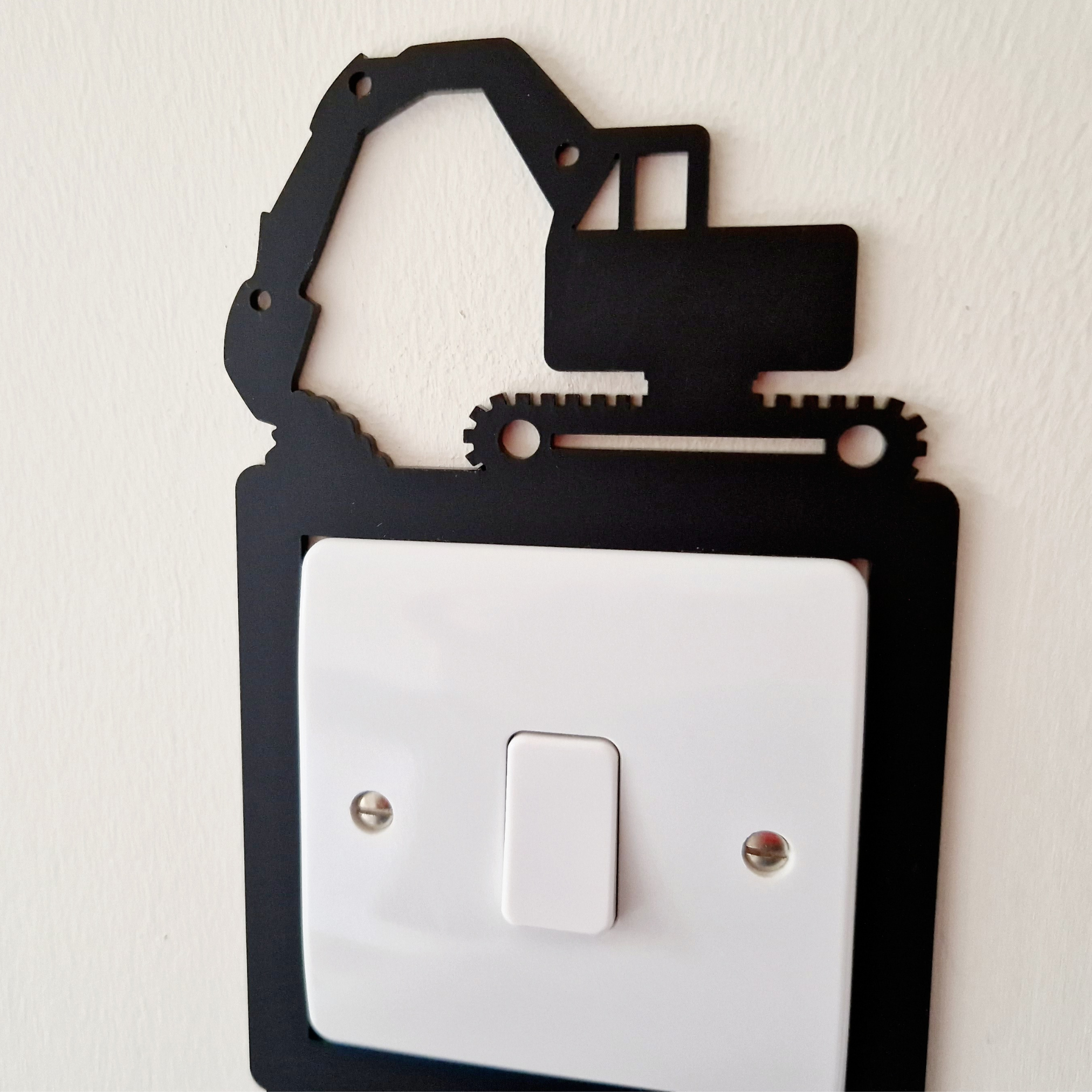 A black and white image of a light switch with a black crane-like object on top of it.