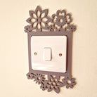 a wall-mounted light switch with a decorative floral design surrounding it.