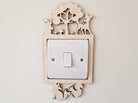 Decorative light switch cover with woodland bunny, deer, fox and squirrel animal design on a plain wall.