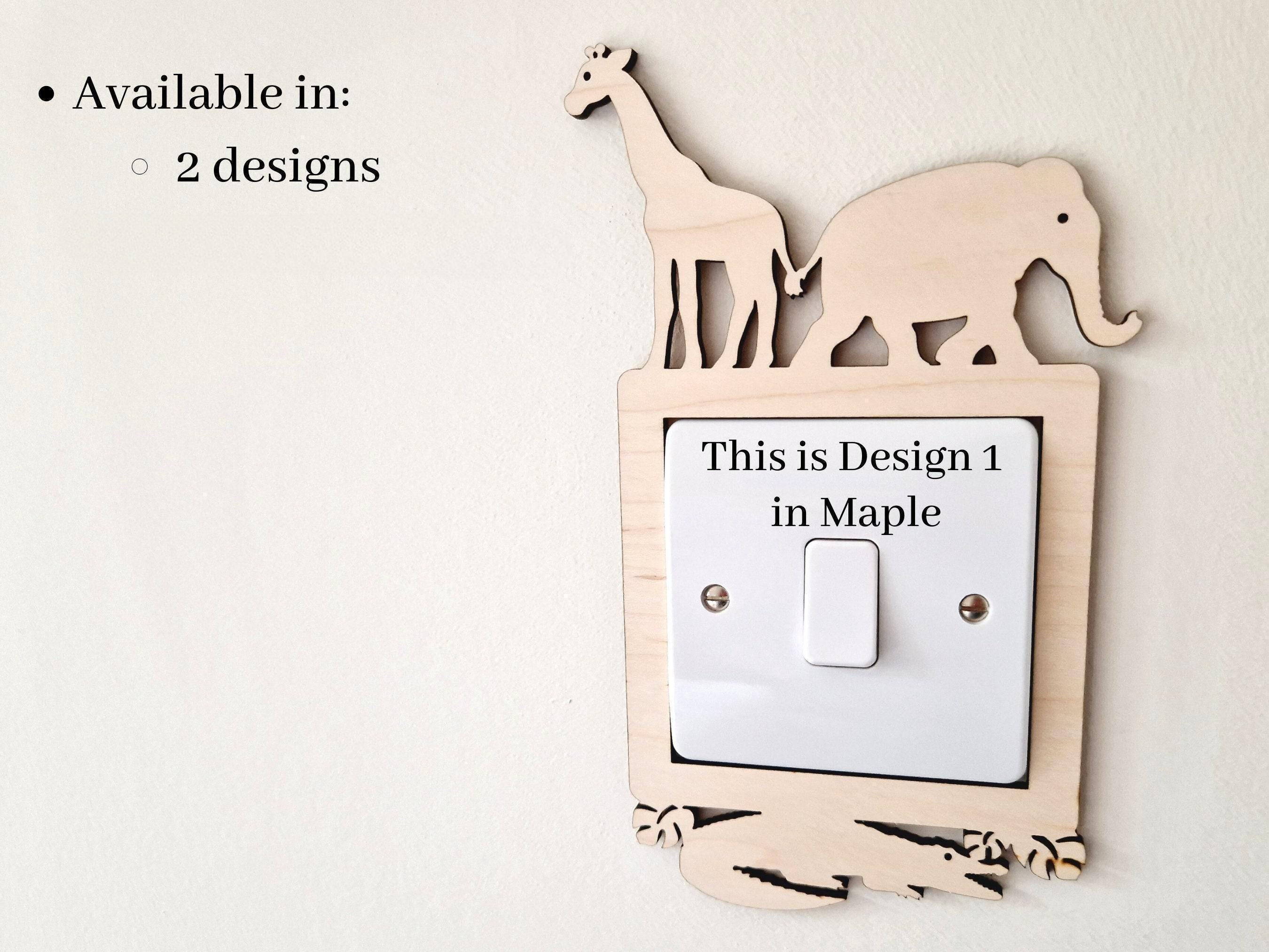 a wooden light switch with a giraffe and an elephant cutout on top, and the switch is labeled as "This is Design 1 in Maple".