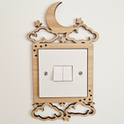 A wooden light switch with a moon and star design on top, featuring a white switch with two light bulbs.