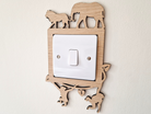 A wooden light switch with a silhouette of an elephant and a lion on it, mounted on a wall.