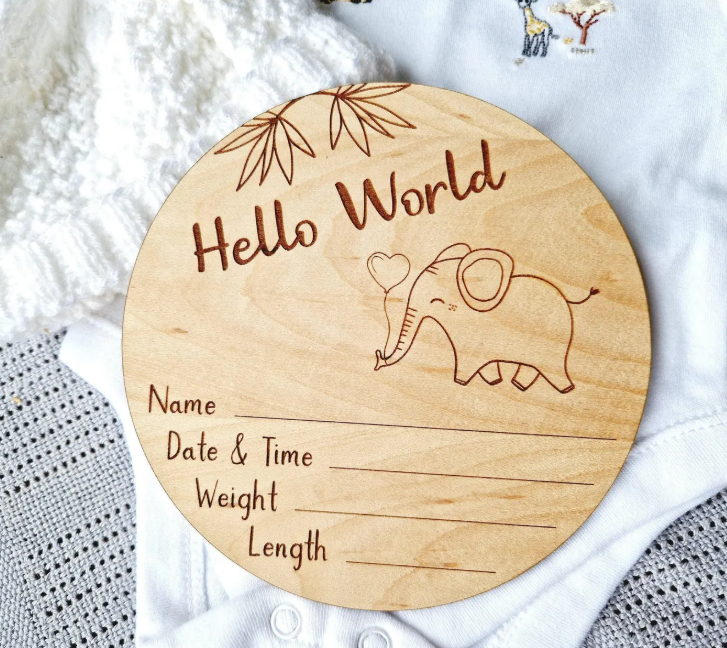 A wooden postcard with a baby elephant and the text "Hello World" written on it.