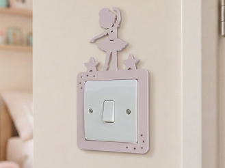 Decorative pink light switch cover with a dancing ballerina design in a child's room.