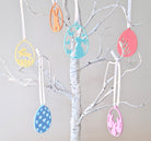 Decorative tree with colorful egg-shaped ornaments on a white background
