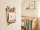Decorative wooden light switch cover with leaf design in a nursery setting