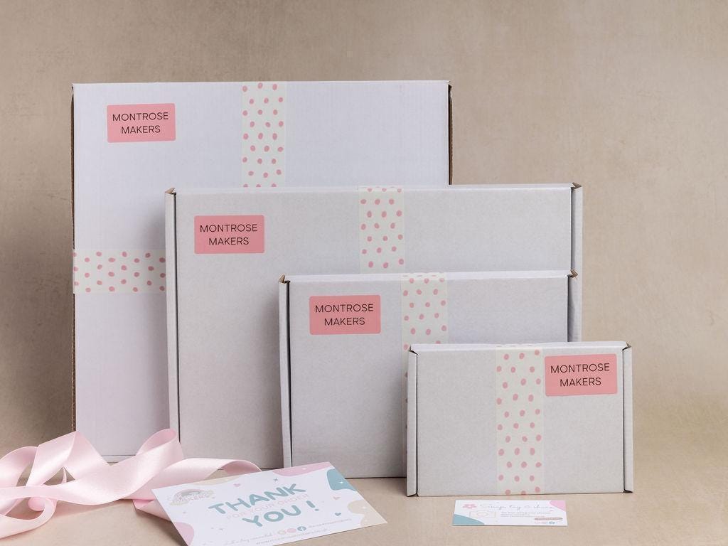 Four Montrose Makers gift boxes in different sizes arranged on a beige background, decorated with pink polka dot patterns and a pink brand label. A pink ribbon and a thank you card are placed in the foreground.