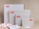 Four Montrose Makers gift boxes in different sizes arranged on a beige background, decorated with pink polka dot patterns and a pink brand label. A pink ribbon and a thank you card are placed in the foreground.