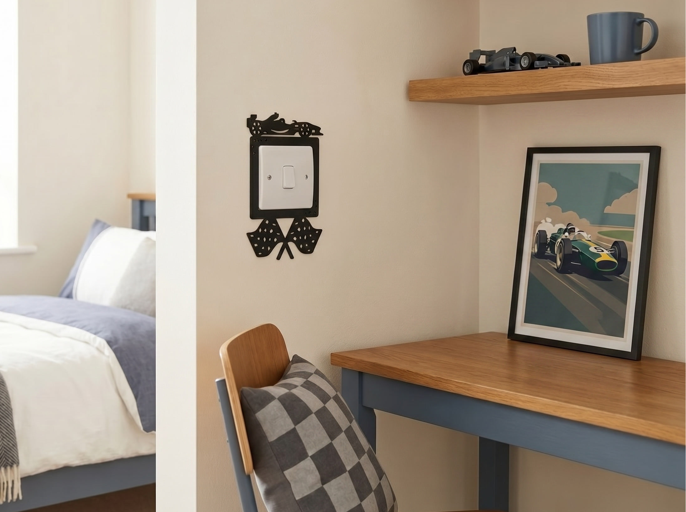 Small bedroom with a bed, desk, and a black switch surround with a racing car and finishing flags. 