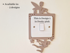 a light switch with a decorative fairy silhouette on it, and there is text indicating that this is the first design in the "Dusky pink" color scheme.