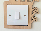 A wooden light switch with a white switch plate mounted on a wall.