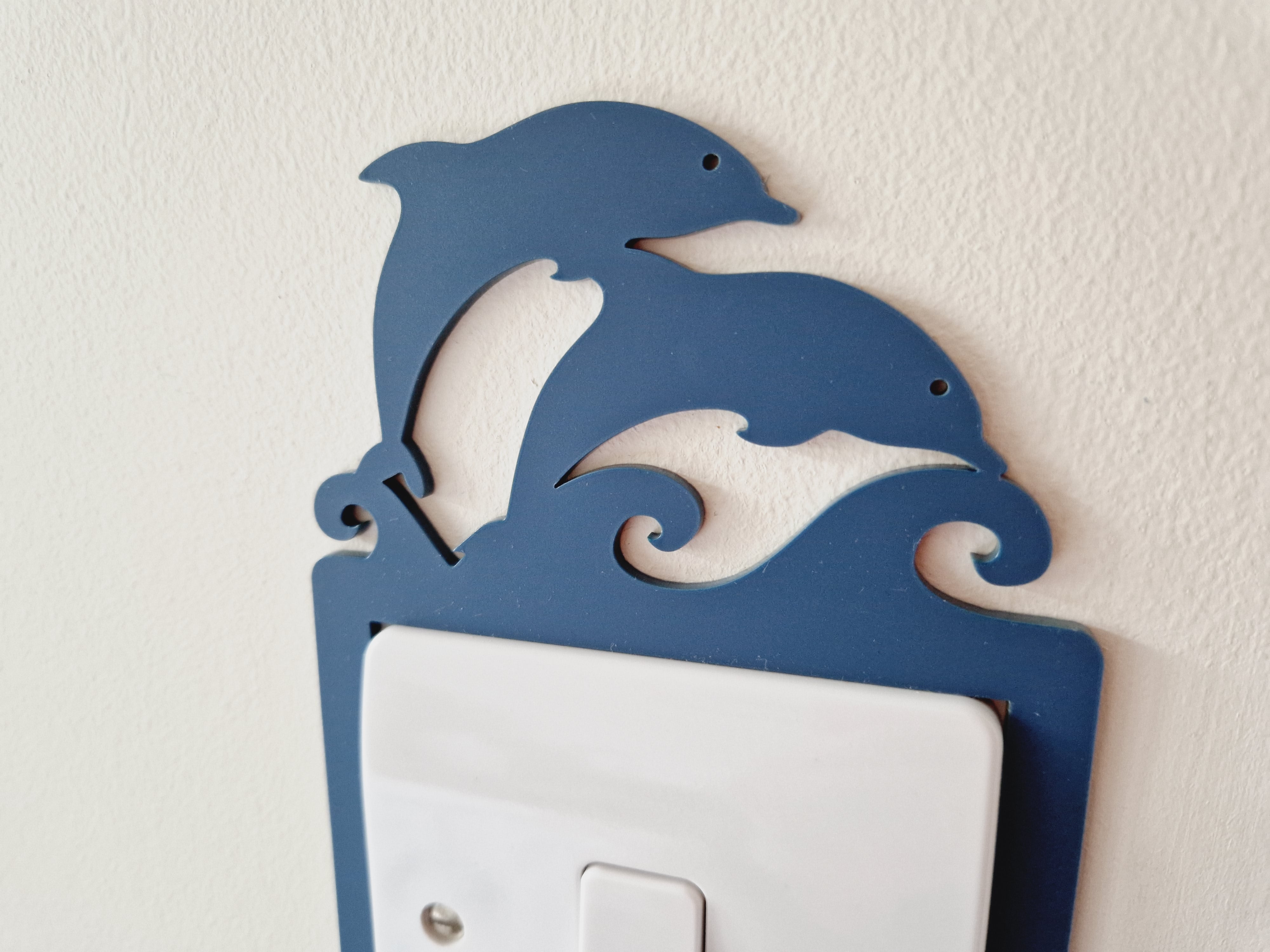 A blue dolphin-shaped light switch on a wall.