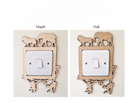 two different wooden light switch covers, each featuring a unique animal silhouette design. The switch cover on the left is labeled "Maple" and the one on the right is labeled "Oak".