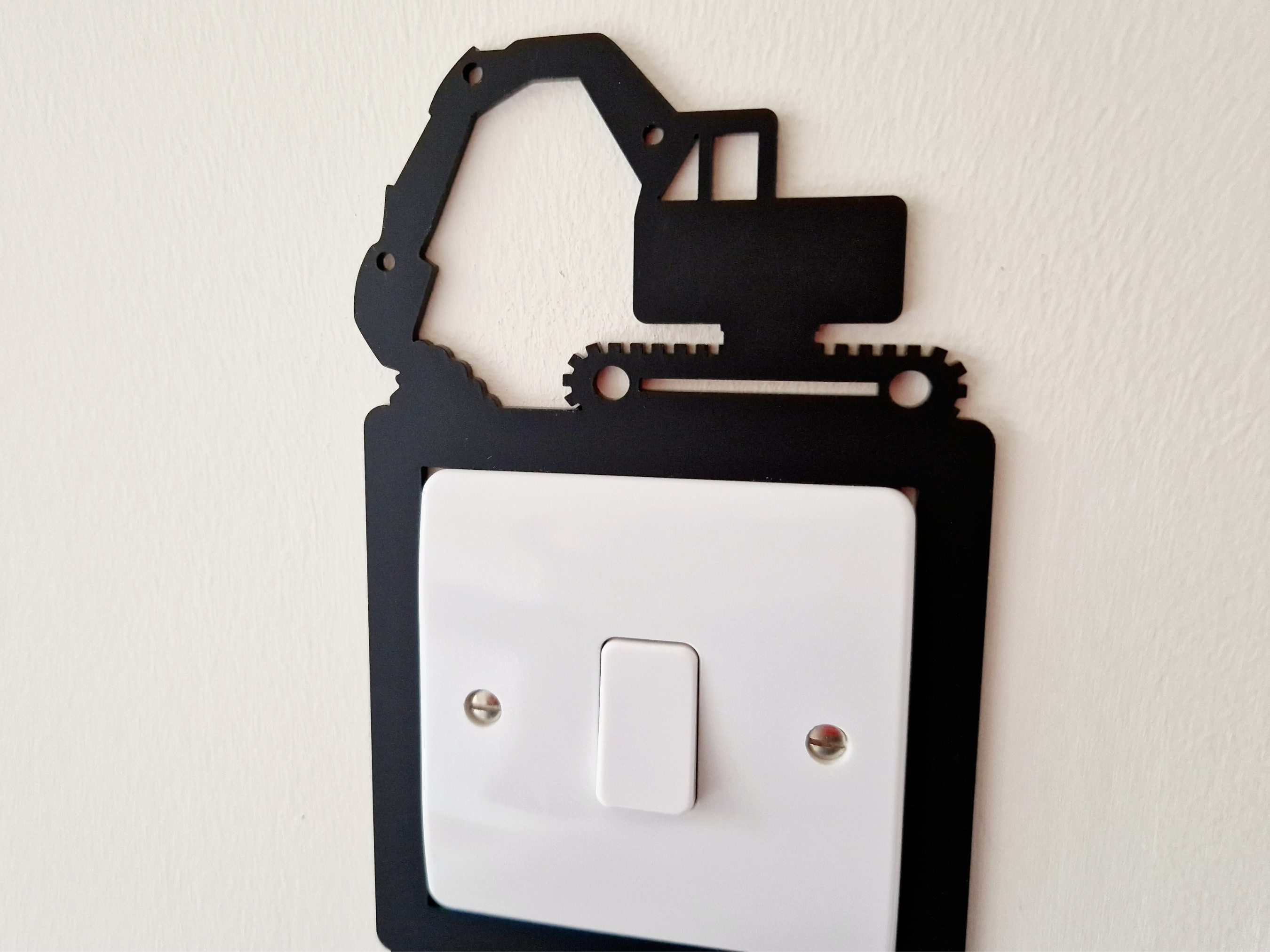 A black and white image of a light switch with a black crane-like object on top of it.
