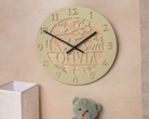 a round wooden clock with the name "Olivia" carved into it, hanging on a wall next to a stuffed teddy bear.